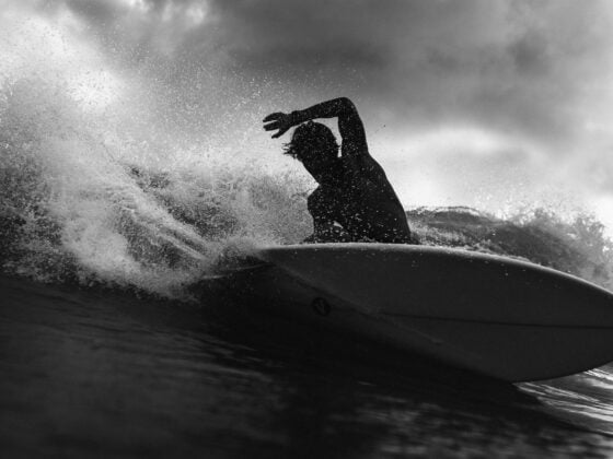 silhouette of unrecognizable surfer on board