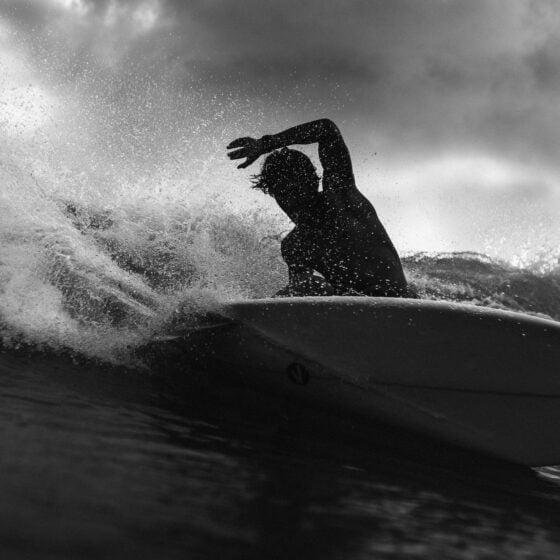silhouette of unrecognizable surfer on board