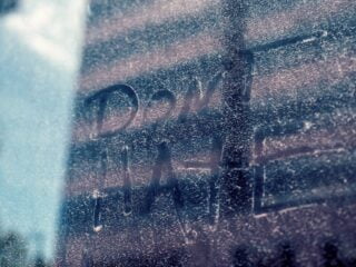 dont hate inscription on glass wall behind building