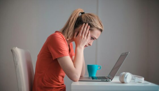young troubled woman using laptop at home