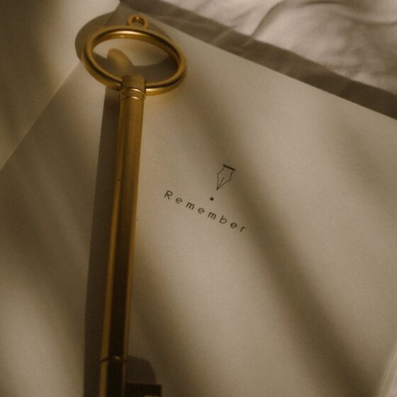 vintage key on open notebook with remember text
