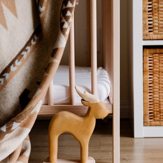 child room with wooden toy near crib