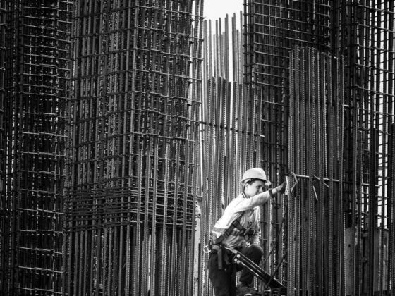 Black and white image of a construction worker climbing steel frameworks in Batumi, Georgia.