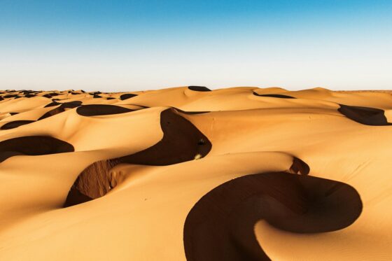Golden sand dunes under a clear blue sky