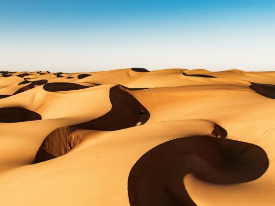 Golden sand dunes under a clear blue sky