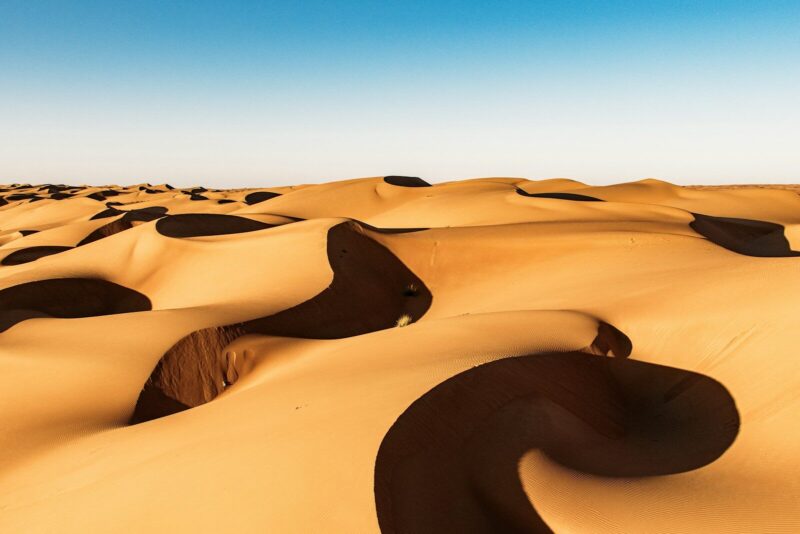 Golden sand dunes under a clear blue sky